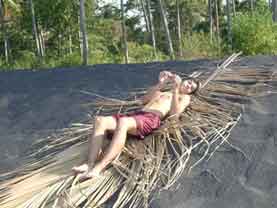 Our son Philip sunbathing in hot black sand